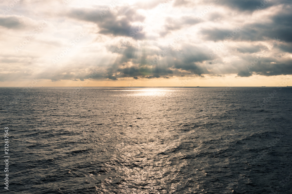 Obraz premium sunlight come through cloud and spray at sea surface