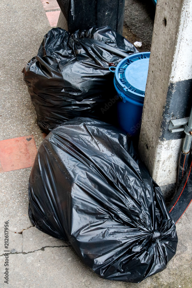 Pile black garbage bag roadside in the city