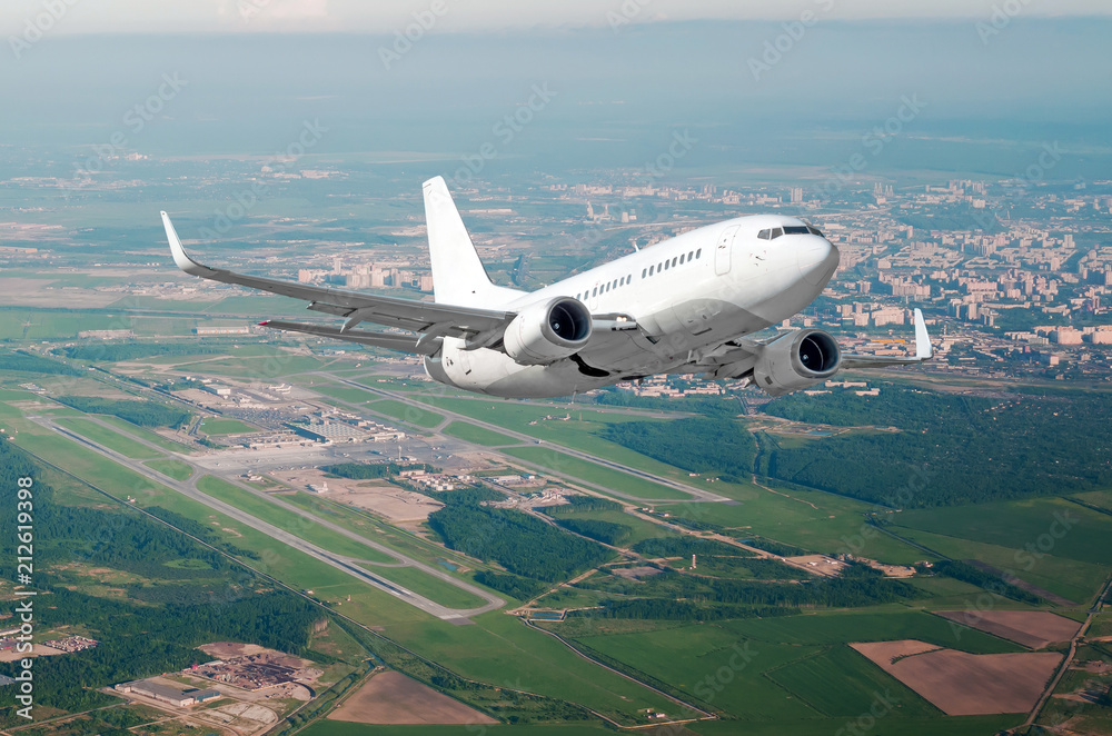Airplane take off from the airport against the background of the city climbs flight level.