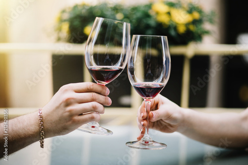 Cheerful couple in a restaurant with glasses of red wine.  Young couple with glasses of red wine in a restaurant with city view