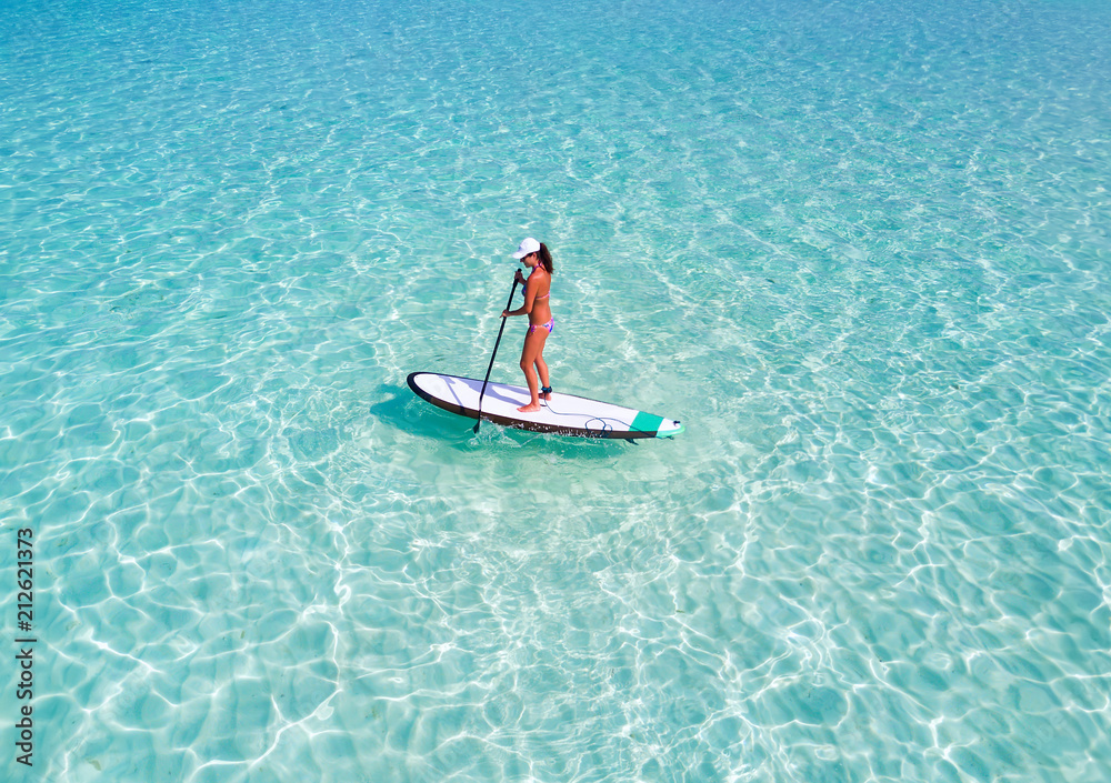 Frau im Bikini auf Stand Up Paddle Brett über türkisem Ozean auf den  Malediven Stock Photo | Adobe Stock