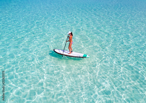 Frau im Bikini auf Stand Up Paddle Brett über türkisem Ozean auf den Malediven  © moofushi