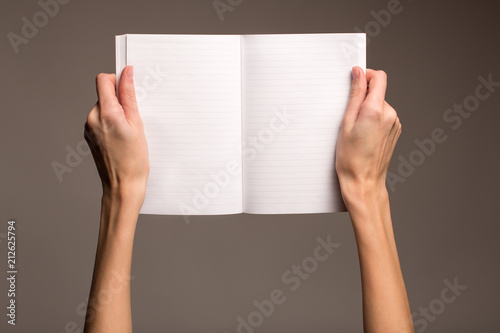  Hands on a gray background with an open book