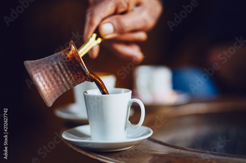 Hand pouring Turkish coffee photo