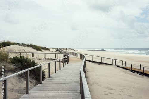 Fototapeta Naklejka Na Ścianę i Meble -  Wooden footbridge of Costa Nova beach, Aveiro, Portugal.