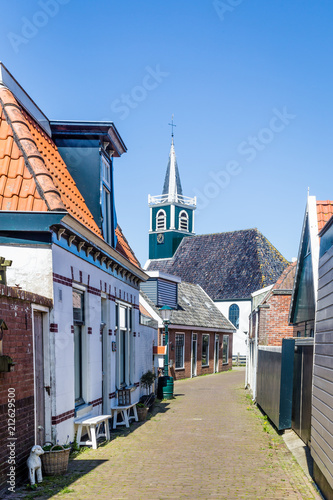 Village Oudeschild with a row of  trraditional fisherman houses and an old church on Texel island in the Netherlands photo