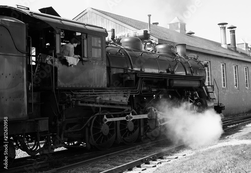 Steam train in rail yard blowing steam
