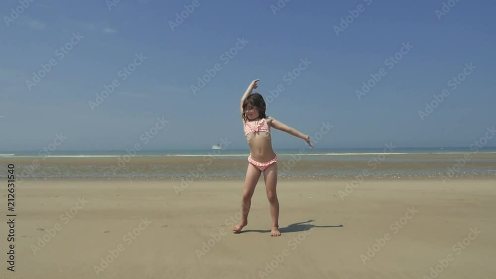 belle enfant faisant la roue sur la plage
(slow motion)
