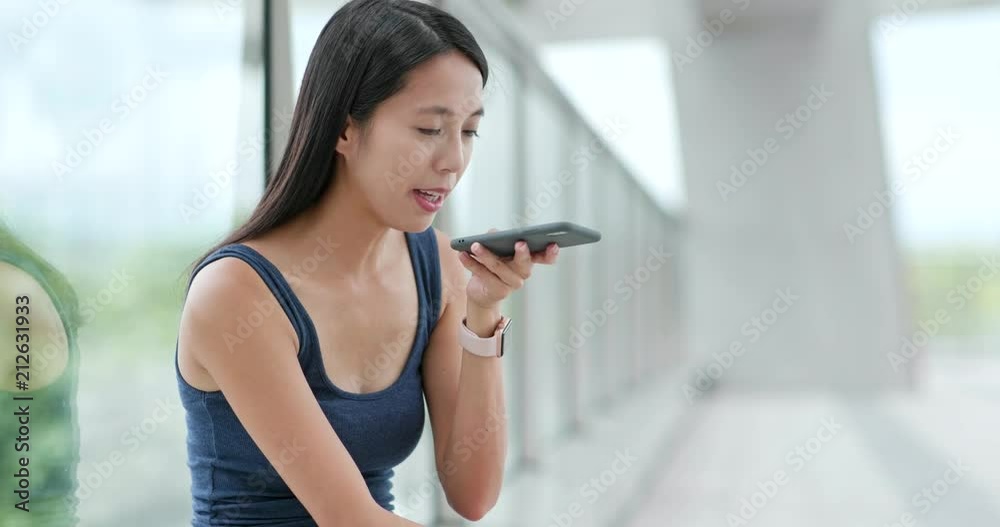 Woman sending audio message on cellphone in city Woman sending audio message on cellphone in city
