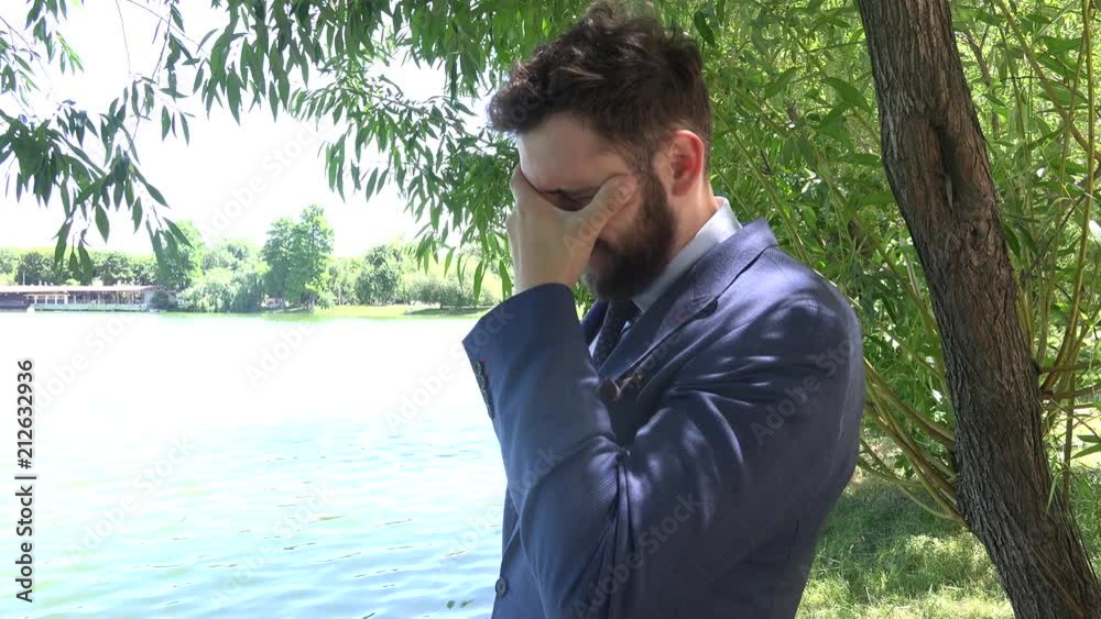 Sick tired overworked depressed young business man worker standing in city park Sick tired overworked depressed young business man worker standing in city park