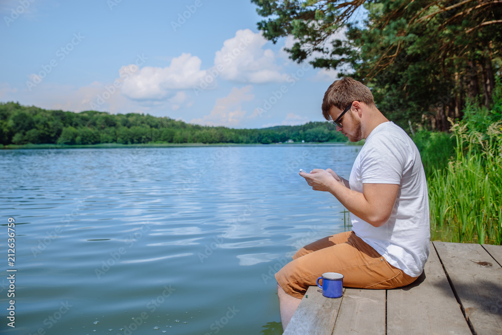 man drinking coffee with beautiful lake view