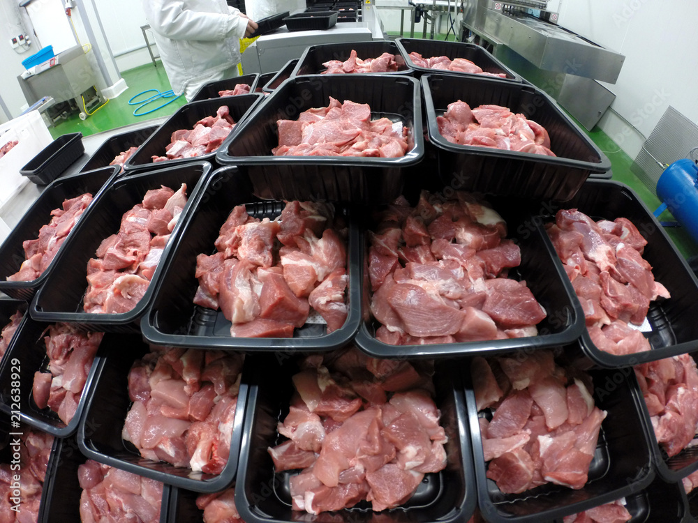 Fresh Meat Slices Packing By Worker Hands At Meat Factory / Raw sliced pork meat in plastic boxes packaging tray