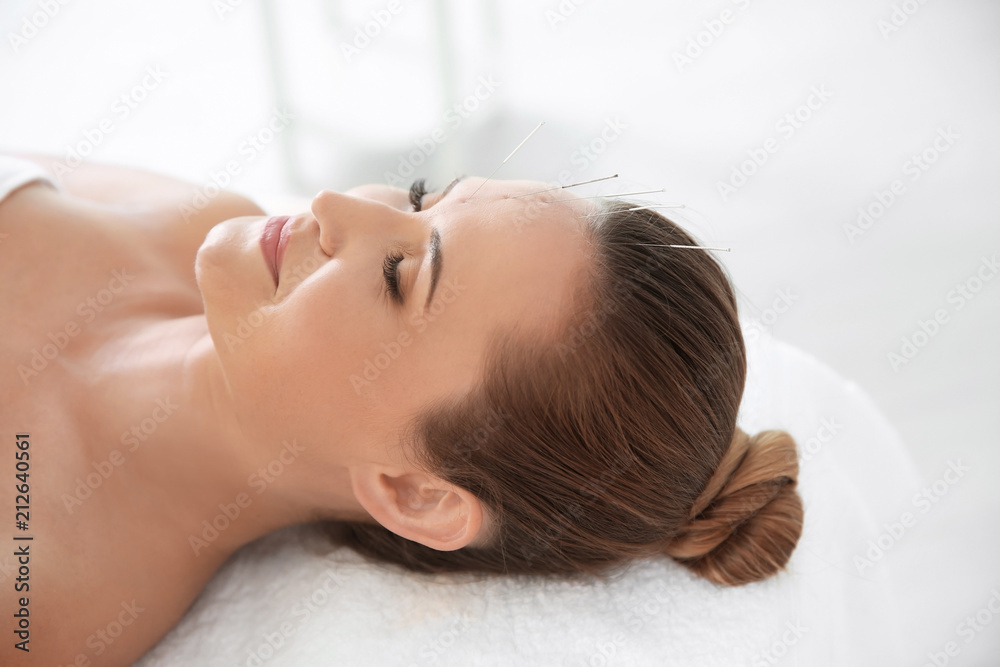 Young woman undergoing acupuncture treatment in salon Young woman undergoing acupuncture treatment in salon