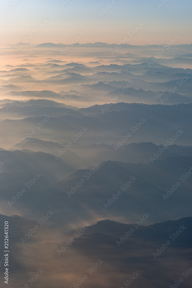 Mountains in the clouds hit by light rays