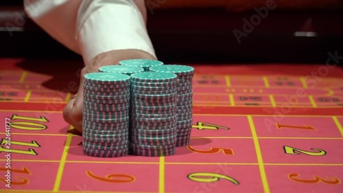 Dealer working , placing bets, collect chips for roulette in casino.