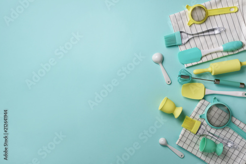 Pastel yellow, blue cooking utensils on turquoise background. Food ingredients. Cooking cakes and baking bread concept. Copy space. Top view. Flat lay