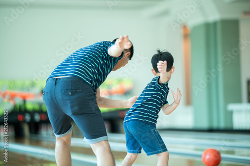 family and young boy in bowling alley