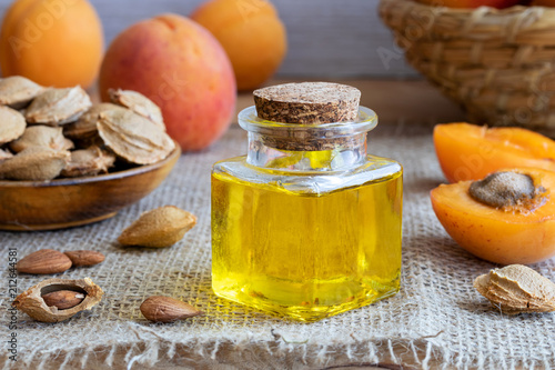 A bottle of apricot kernel oil with fresh apricots
