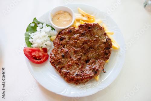 Delicious food, pljeskavica - tasty grilled dish of spiced meat patty mixture of pork, beef and lamb, is a national dish of Montenegro, Serbia, also popular in Bosnia and Herzegovina and Croatia
