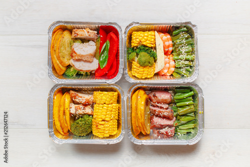 Healthy meal prep containers with vegetables, chicken, beef and shrimp grilled. Close-up, view top.