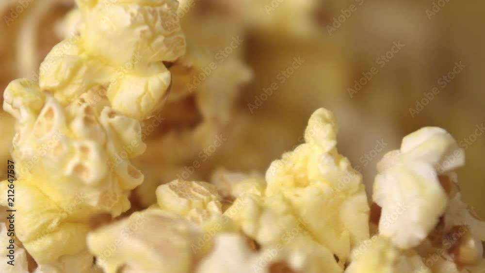 Cinema popcorn background. Ready popcorn flakes falling into heap in