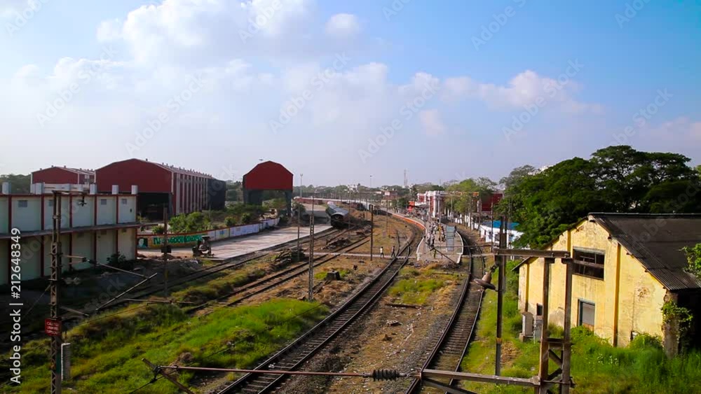 Commuters walk on the platform and crosses train tracks, People waiting for their trains in the India. Commuters walk on the platform and crosses train tracks, People waiting for their trains in the India.