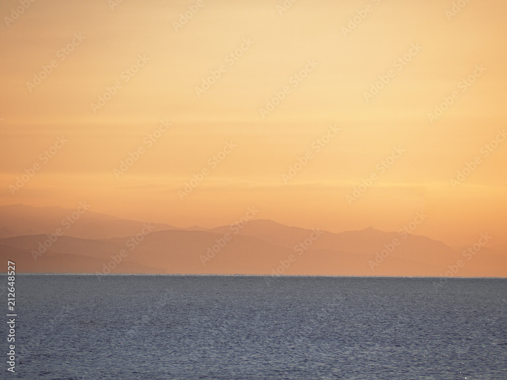 the sea and mountains during sunrise