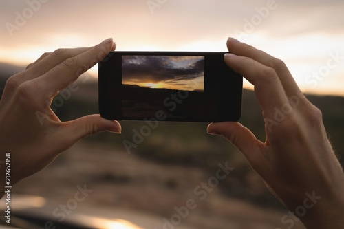 Woman taking picture of nature with mobile phone photo