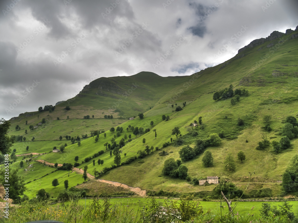 Verde ladera de los Valles Pasiegos en Cantabria.con la cumbre con nubes. Verde ladera de los Valles Pasiegos en Cantabria.con la cumbre con nubes.