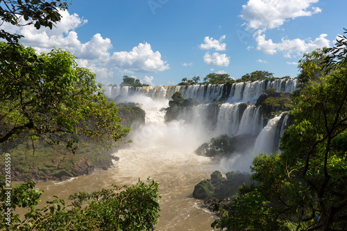 Waterfalls at Iguazu falls framed by trees and blue sky