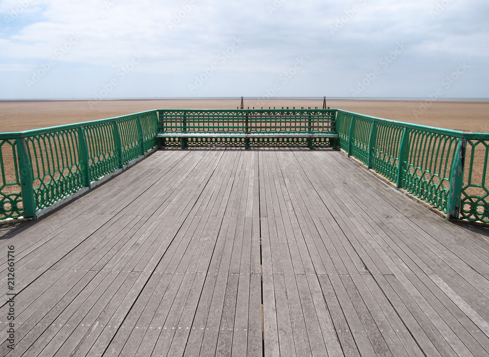 the end of the victorian pier at St Annes on sea in lancashire looking out onto the beach at low tide with the sea in the far distance on a bright summer day