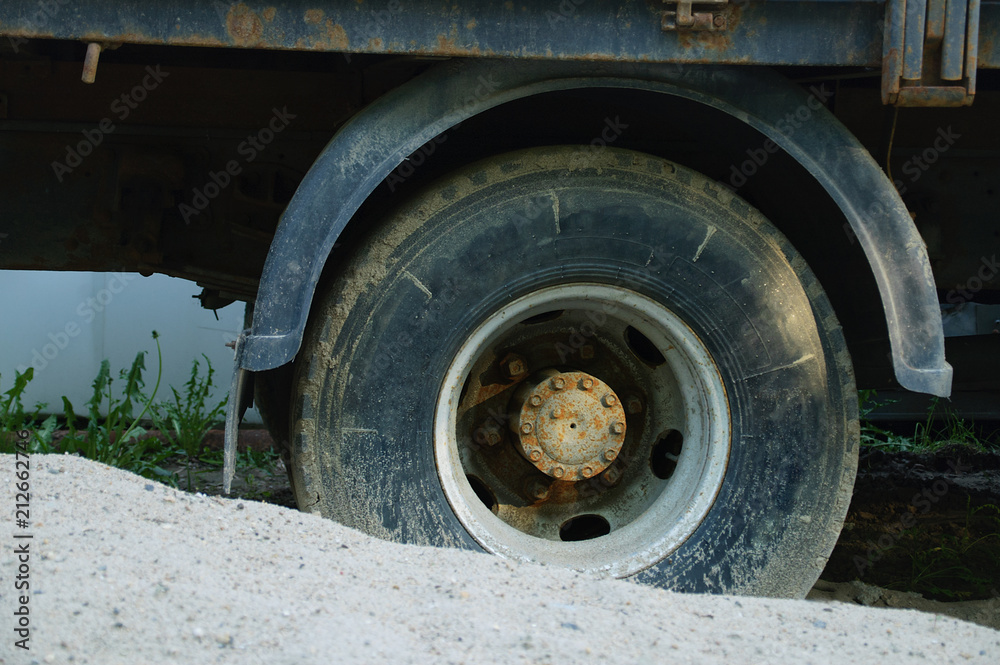 Stuck in the sand dirty wheel of a truck. Close-up.