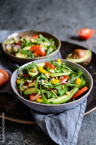 Healthy arugula salad with avocado, radish, bell pepper, tomato and Roquefort cheese