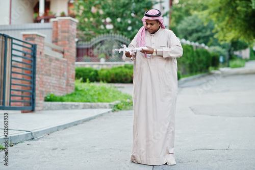 Middle Eastern arab business man posed on street with drone or quadcopter at hands.