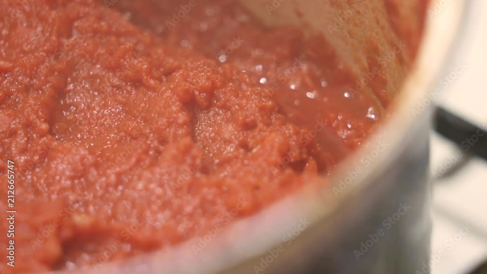 Сooking homemade tomato pasta sauce. Hot sauce cooked from fresh tomatoes boiling in pot closeup Сooking homemade tomato pasta sauce. Hot sauce cooked from fresh tomatoes boiling in pot closeup
