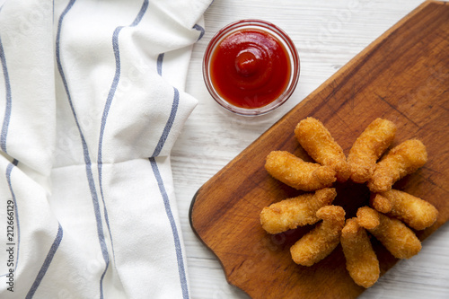 Fried shrimps tempura with sauce and striped napkin on wooden board over white wooden surface, top view. From above, overhead, flat lay.