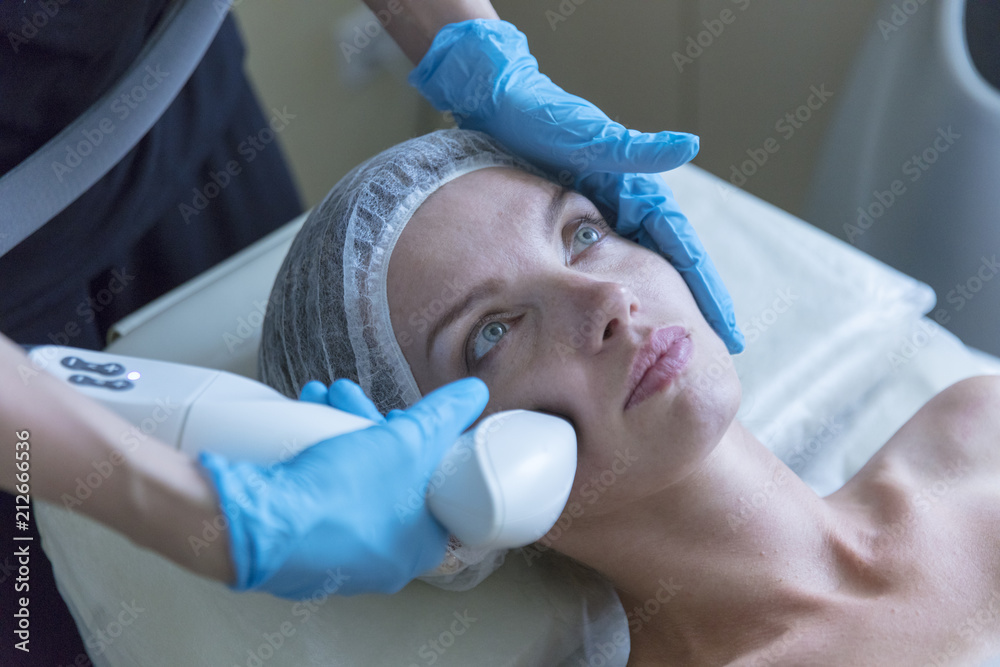 Fototapeta premium Beautiful woman in professional beauty salon during photo rejuvenation procedure