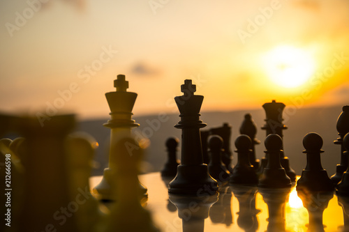 chess board game concept of business ideas and competition and strategy ideas. Chess figures on a chessboard outdoor sunset background.