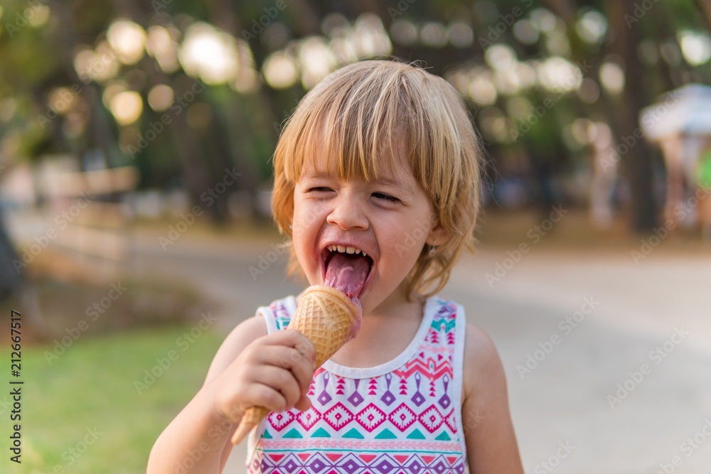 Happy toddler child eating an ice cream. Happy toddler child eating an ice cream.
