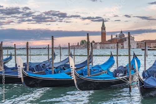 Many gondolas in Venice in Italy at sunset. © vchalup