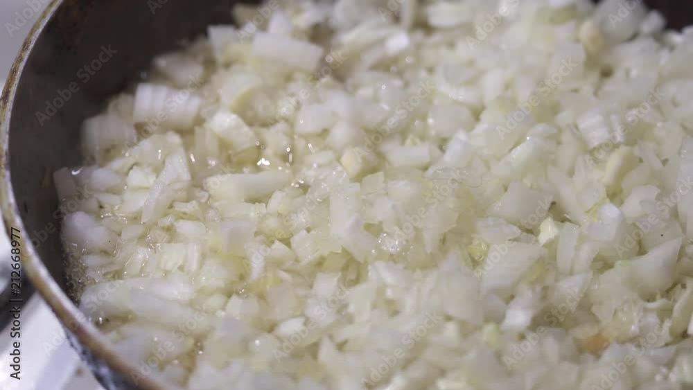 Fried chopped onion in hot boiling oil. Closeup of frying pan. Сooking vegetables Fried chopped onion in hot boiling oil. Closeup of frying pan. Сooking vegetables