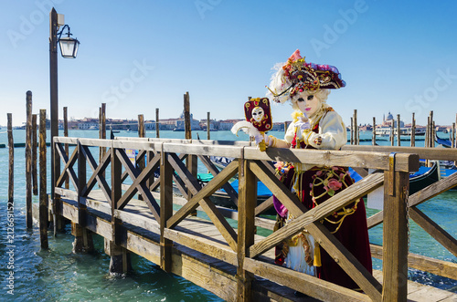 Venice carneval mask leaning on a bridge