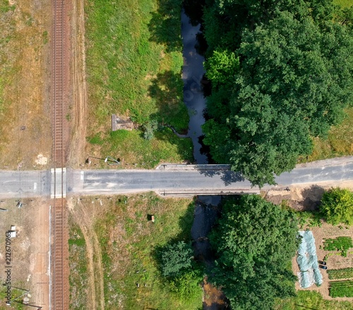 Aerial view on railroad in forest with road and river