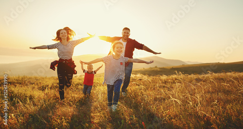 Happy family: mother, father, children son and daughter on sunset photo