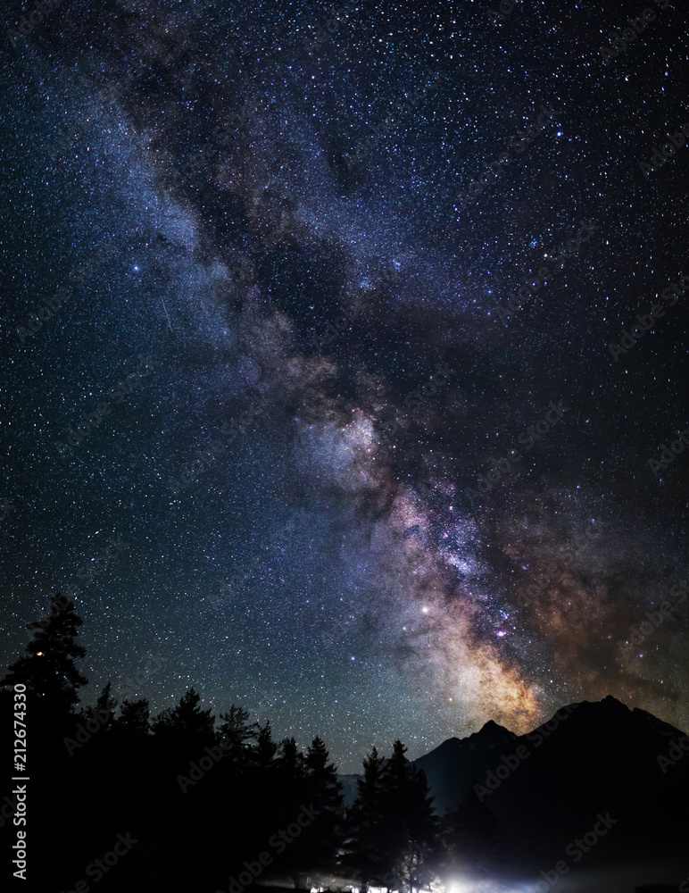 Astrophotography of Milky Way galaxy. Silhouette of mountains. Stars, nebula and stardust at night sky landscape