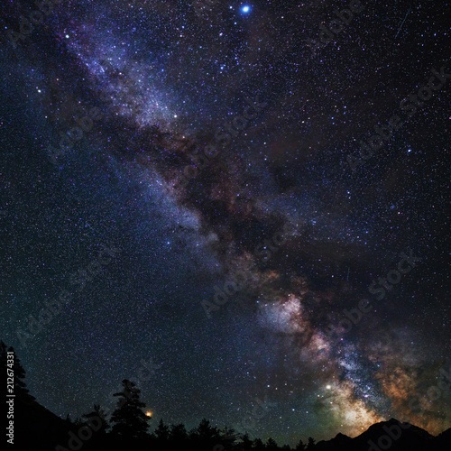 Astrophotography of Milky Way galaxy. Silhouette of mountains. Stars, nebula and stardust at night sky landscape