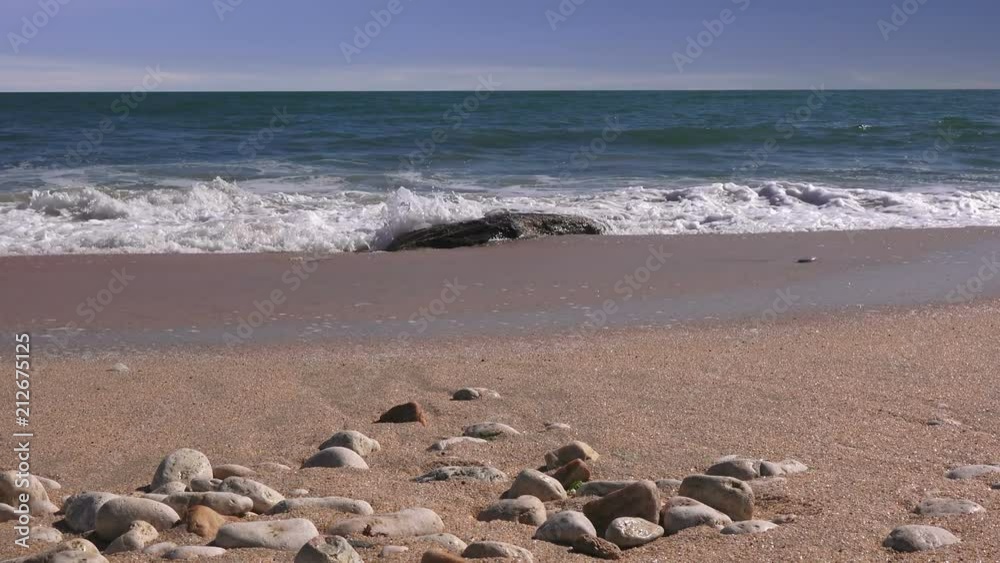 Close up of sea pebbles against the backdrop of a stormy sea in sunny day Close up of sea pebbles against the backdrop of a stormy sea in sunny day