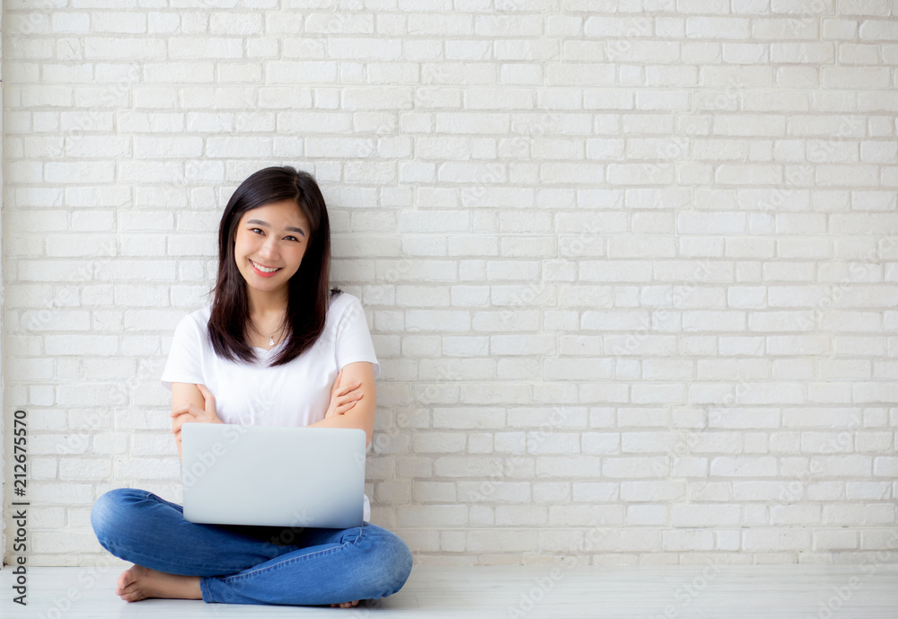 Beautiful of portrait asian young woman excited and glad of success with laptop computer, girl sitting working on cement brick background, career freelance business concept. Beautiful of portrait asian young woman excited and glad of success with laptop computer, girl sitting working on cement brick background, career freelance business concept.
