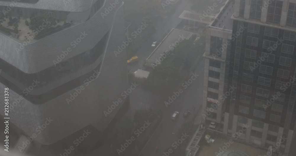 Focus pull from grey dark city below to a rainy window above