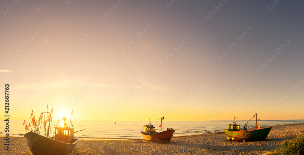 Naklejka premium fisherman boats at sunrise time on the beach